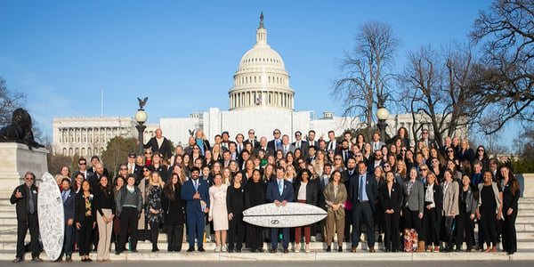 Group of Surfrider Foundation volunteers in Washington, DC, for Environmental lobby days, holding a signed surfboard to show support.