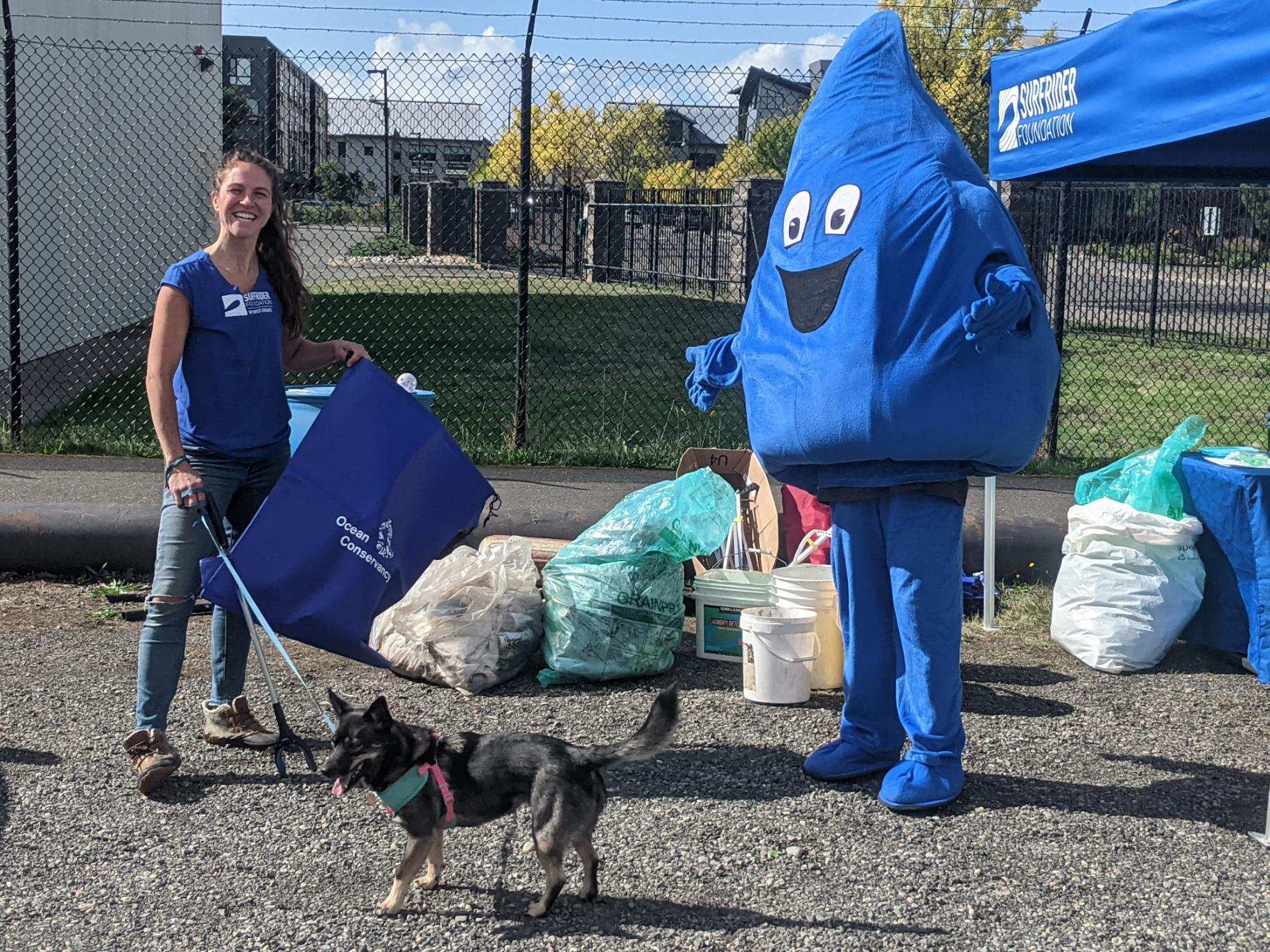 surfrider foundation volunteers at a beach cleanup holding their collected trash with the Clean Water drop mascot! 